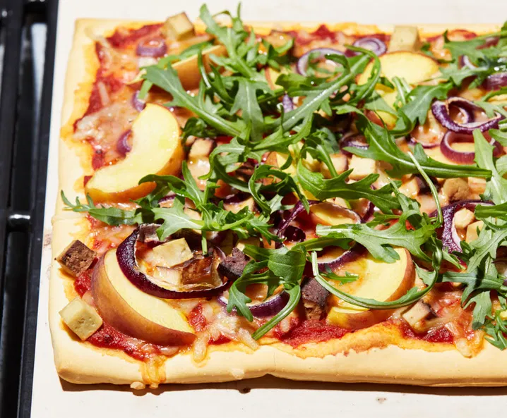 Vegán pizza füstölt tofuval, őszibarackkal és rukkolával