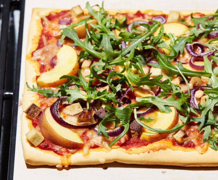 vegane Pizza mit Räuchertofu, Pfirsich und Rucola