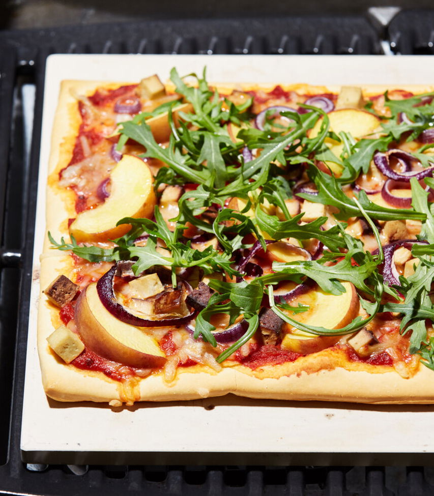 vegane Pizza mit Räuchertofu, Pfirsich und Rucola