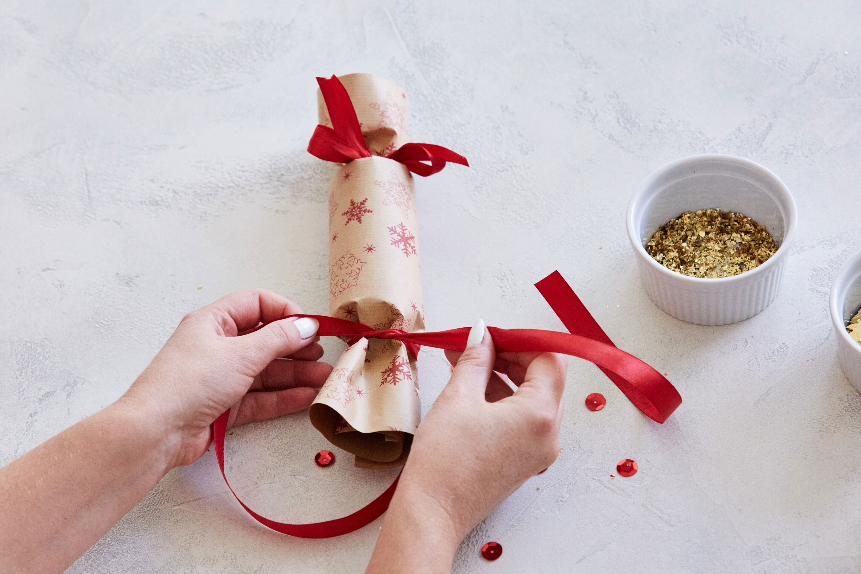 Schritt 8: Zum Schluss bindest du noch die zweite Seite mit Geschenkband zu. Fertig. Frohes Knallen!