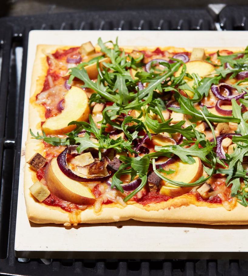 Vegan pizza met gerookte tofu, perzik en rucola